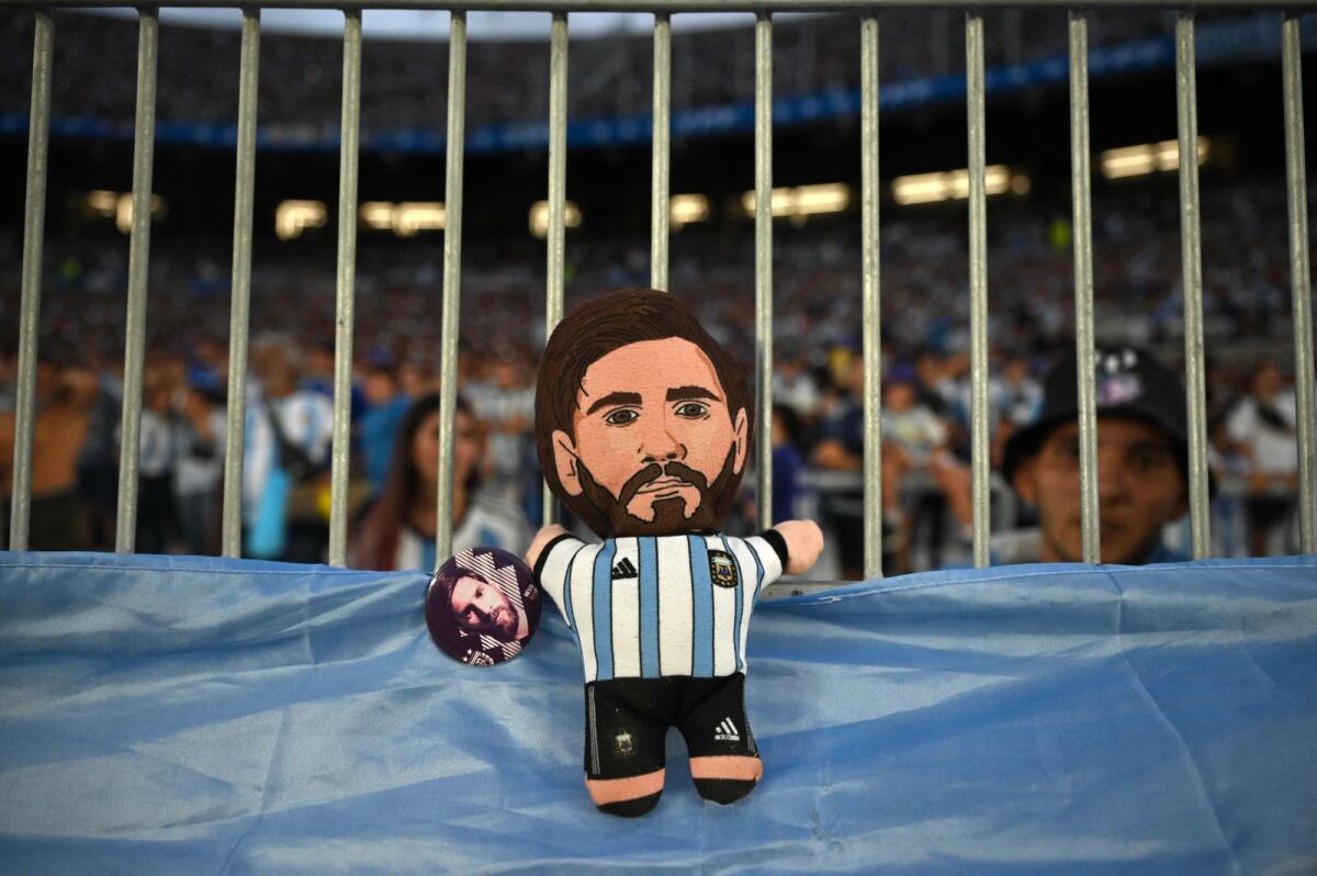 A doll depicting Lionel Messi is seen on the stands during the friendly match. — AFP