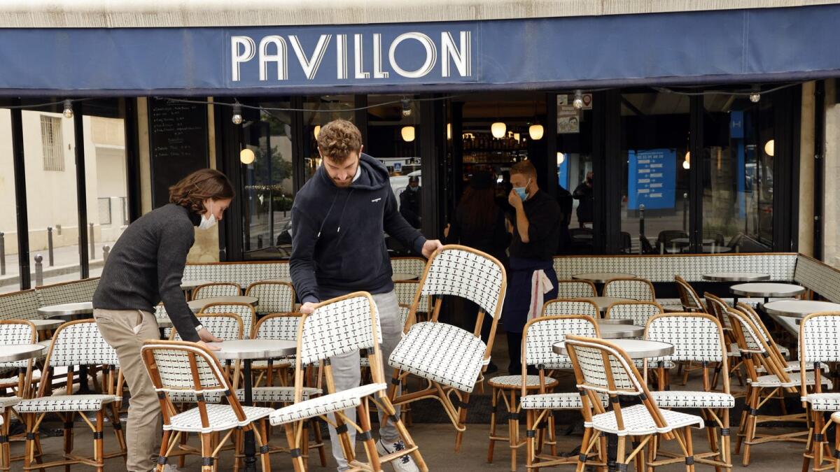 Employees set up a cafe's terrace in Paris, ahead of the reopening of bars and restaurant in France. Photo: AFP