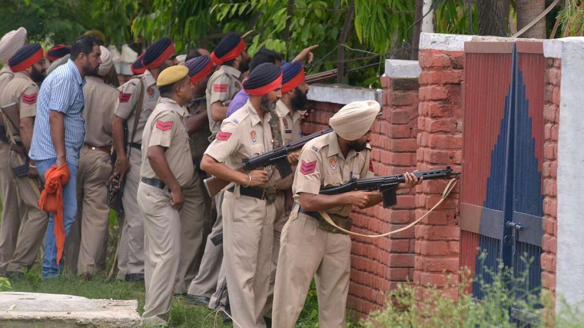Indian Punjab police personnel take position during an encounter with armed attackers at the police station in Dinanagar town, in the Gurdaspur district of Punjab state.