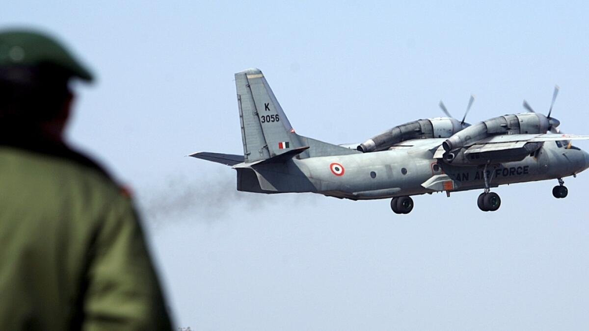 A soldier stands guard as an Indian Air Force AN-32 transport aircraft carrying security personnel takes-off.- Reuters