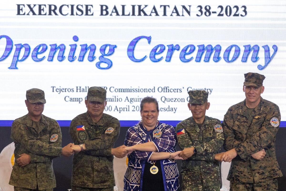 Philippines Exercise Director Major General Marvin Licudine, Philippine Military Chief Andres Centino, US Embassy representative Heather Variava, Philippine Military Deputy Chief of Staff for Education, Training and Development Major General Noel Beleran, and US Exercise Director representative Major General Eric Austin link arms during the opening ceremony of the annual Philippines-US joint military exercises or Balikatan, at the Armed Forces of the Philippines headquarters, in Quezon City, Metro Manila, on Tuesdsy.-- Reuters