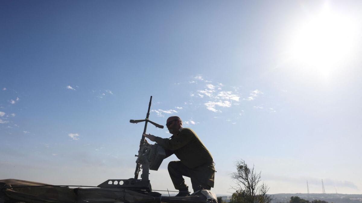 An Israeli soldier adjusts a weapon on top of a vehicle near Israel's border with Gaza. — Reuters