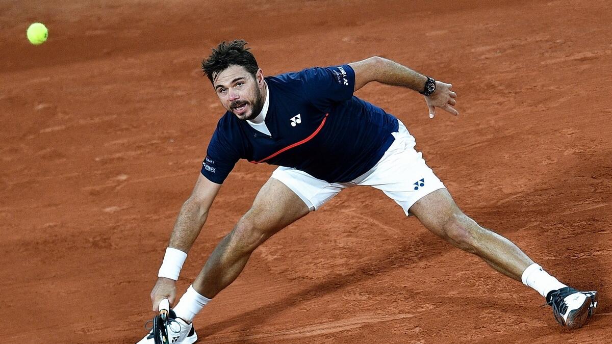 Switzerland's Stanislas Wawrinka returns the ball to Britain's Andy Murray during their men's singles first round tennis match on Day 1 of  the French Open