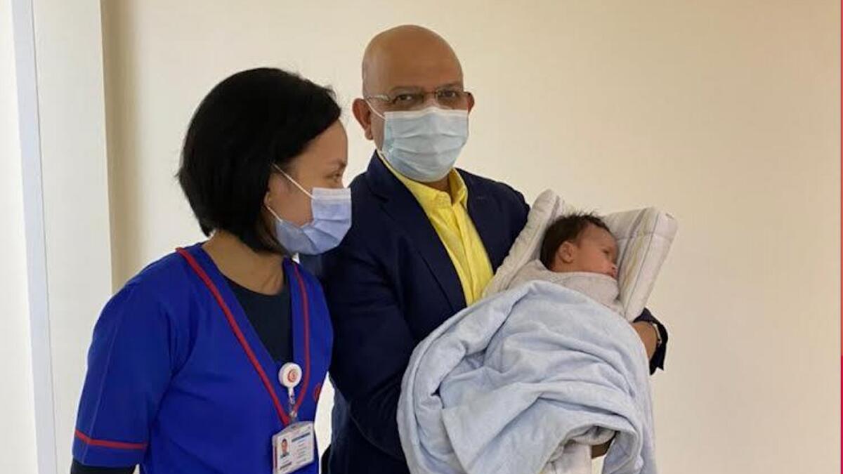 Dr Sandip Mitra (right) with the Omani baby after surgery. — Supplied photo