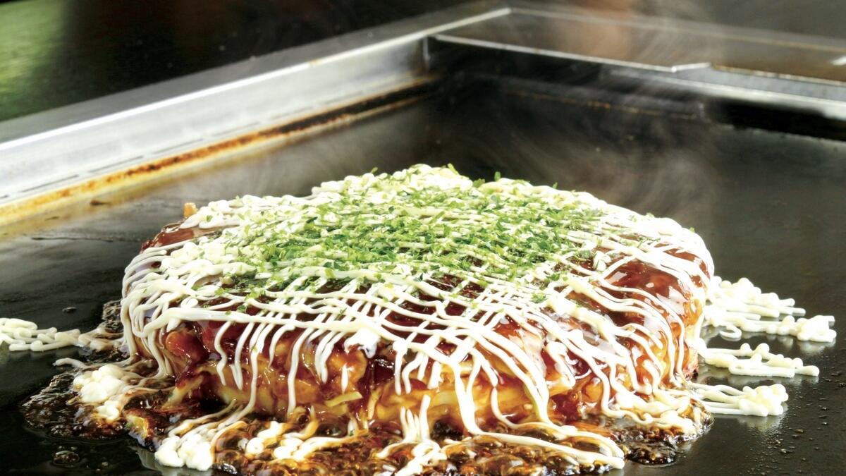 Indulge in okonomiyaki — a pancake that features a delicious blend of vegetables, poultry, seafood, etc.