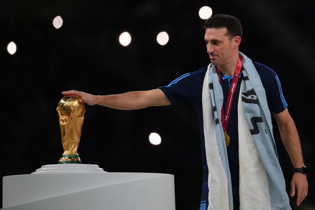 Argentina's coach Lionel Scaloni touches the World Cup trophy after his team won the final. (AFP)