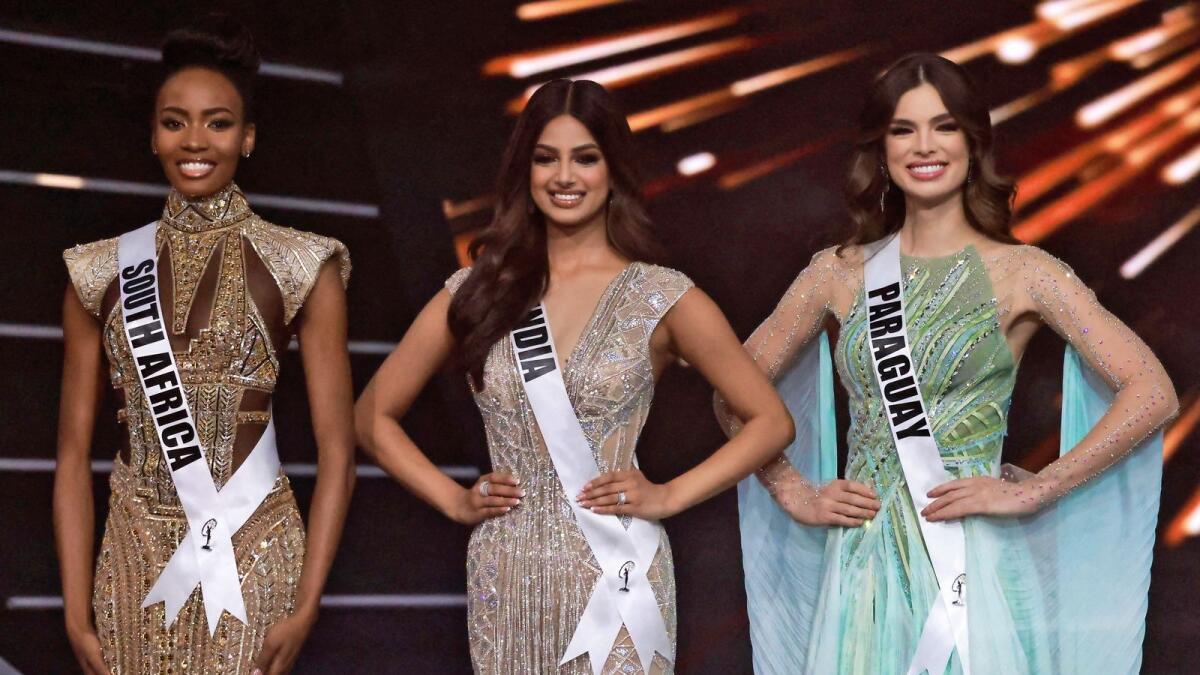The final three Miss Universe contestants (L to R) Miss South Africa, Lalela Mswane; Miss India, Harnaaz Sandhu; and Miss Paraguay, Nadia Ferreira pose on stage during the 70th Miss Universe beauty pageant in Israel's southern Red Sea coastal city of Eilat on December 13, 2021.  (Photo by Menahem KAHANA / AFP)