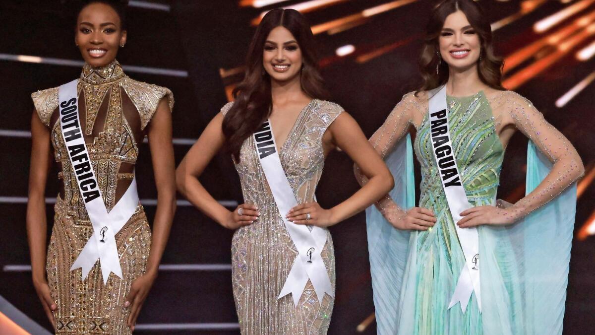 The final three Miss Universe contestants (L to R) Miss South Africa, Lalela Mswane; Miss India, Harnaaz Sandhu; and Miss Paraguay, Nadia Ferreira pose on stage during the 70th Miss Universe beauty pageant in Israel's southern Red Sea coastal city of Eilat on December 13, 2021.  (Photo by Menahem KAHANA / AFP)