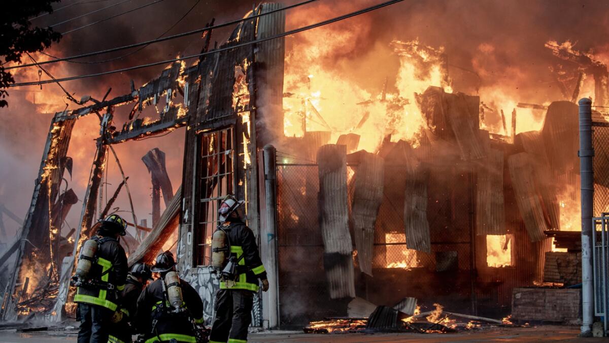Firefighters battle a fire at the South of Market neighborhood of San Francisco. About 150 firefighters battled a massive blaze that raged through three buildings, sending a thick, black plume of smoke up to the sky and embers to a nearby freeway. Photo: AP