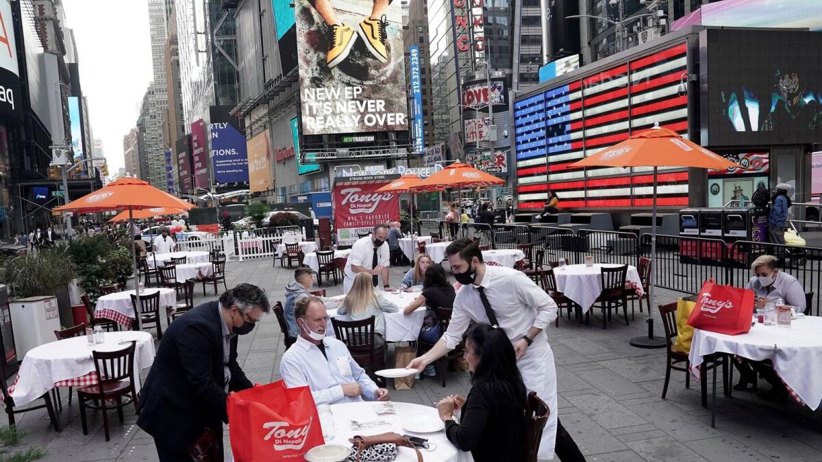 Servers deliver food to a table at a pop-up restaurant set up in Times Square , New York, this month.