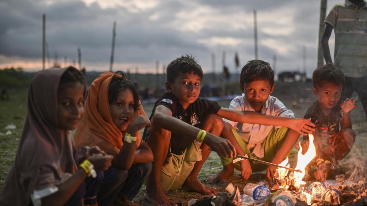 Ethnic Rohingya children sit around a fire at their camp near a beach in Pidie. — AP