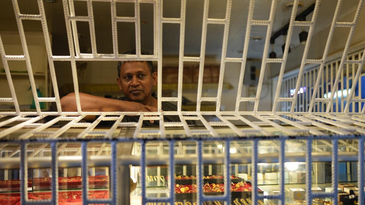 Goldsmith and jewelry maker Andrew Rampersaud waits for customers at his jewelry shop at Stabroek Market in Georgetown, Guyana. Guayana's transformation has lured back locals such as Rampersaud, a 50-year-old who left Trinidad last July with his wife and four daughters. — AP