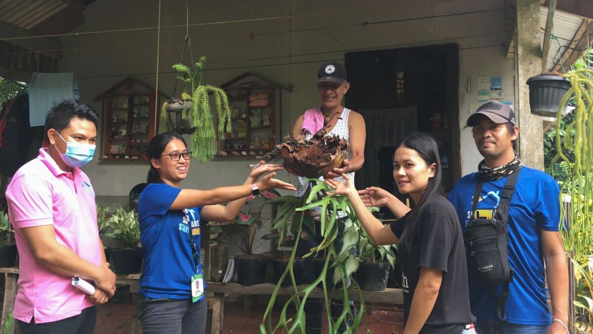Resident Galileo Emperado (top C) posing with DENR officials while handing over an endangered staghorn fern plant from his yard in Zamboanga city, southern Mindanao.