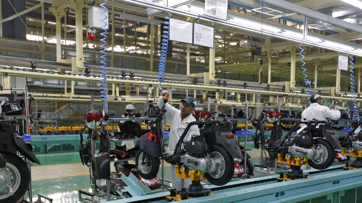 Employees work on an assembly line of Honda Motorcycle &amp; Scooter India in Gujarat. — Reuters file