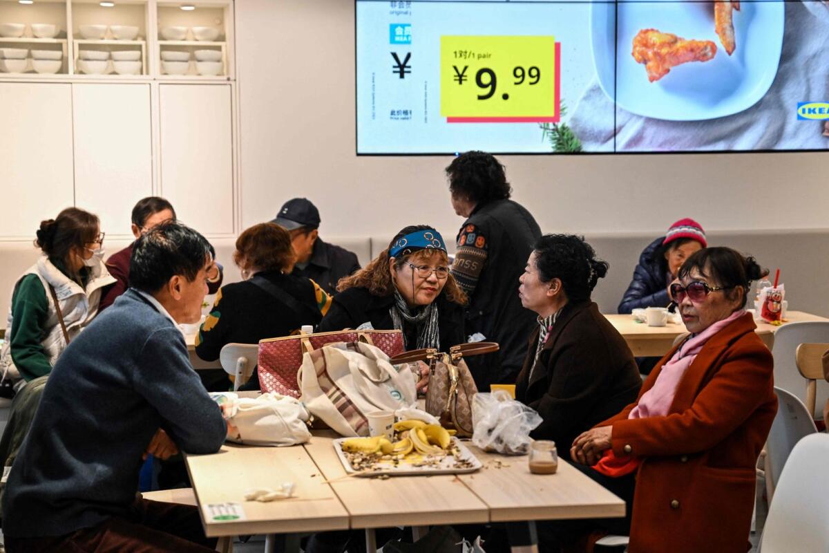 Xu Yizhen (C), a retired doctor, talking with her friends at the Ikea restaurant, where elderly people gather every Tuesday, in the Xuhui district in Shanghai. — AFP
