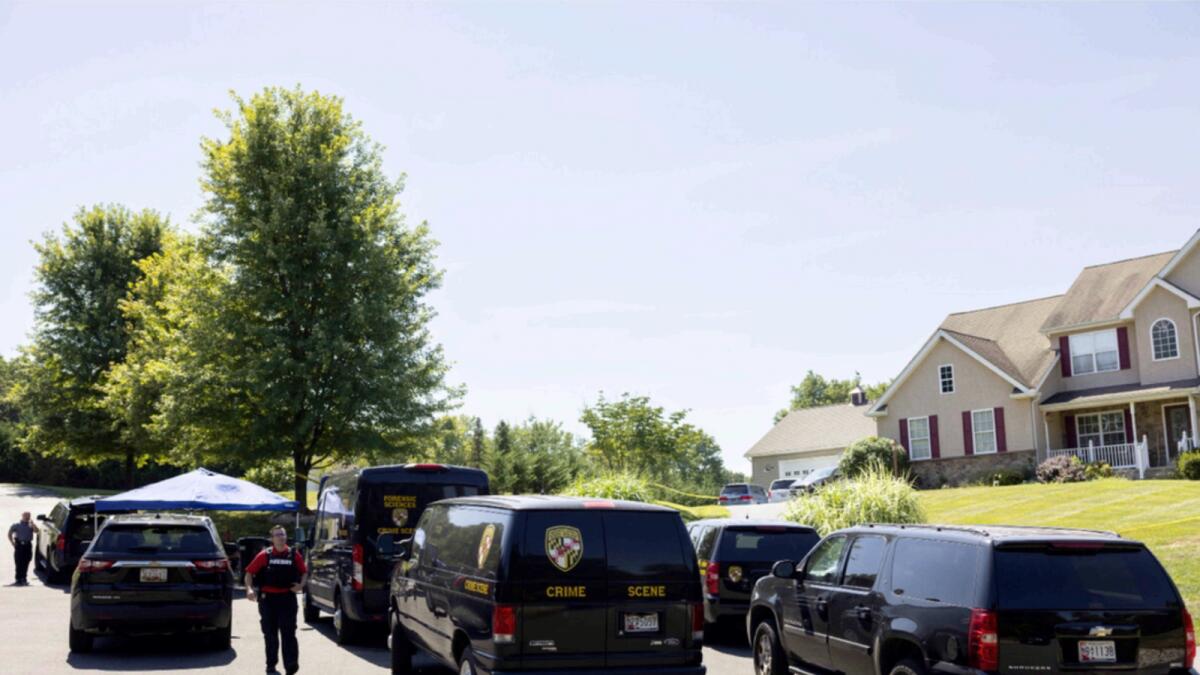 Forces at a home in Maryland where five people where found shot to death. — AP