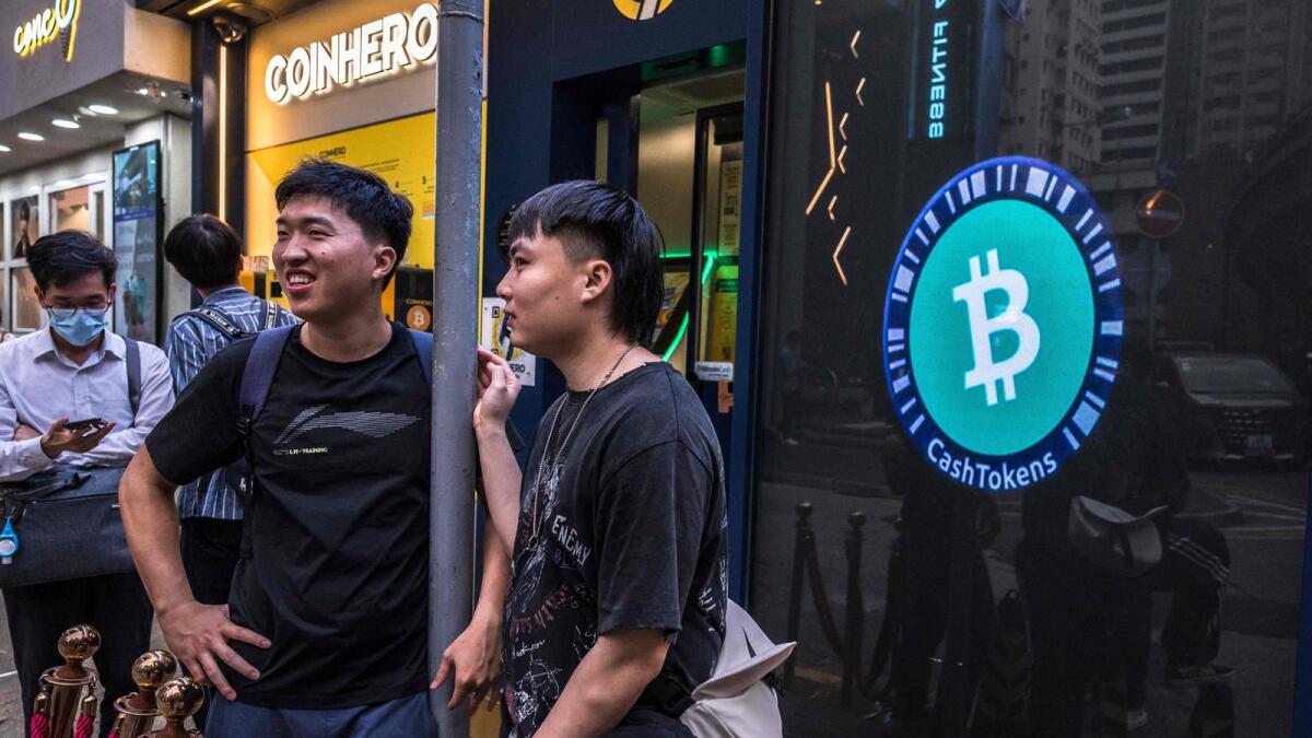 People stand outside a cryptocurrency exchange in Hong Kong . In the UAE, crypto assets have emerged as the predominant investment choice among retail investors. — AFP