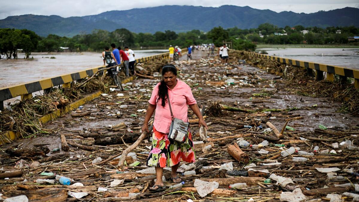 A woman walks among debris on a bridge over the Chamelecon river after the passage of Storm Eta, in Pimienta, Honduras November 6, 2020.