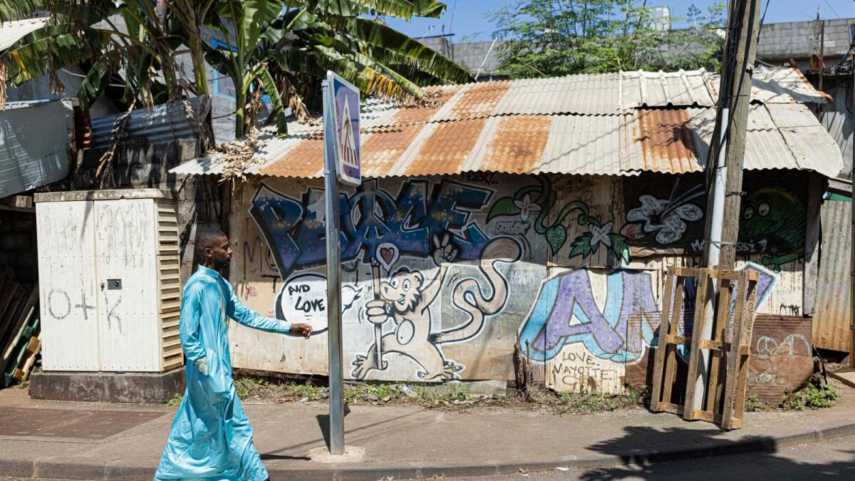 A man walks in the streets of Kaweni, Mamoudzou, on the island of Mayotte on April 26, 2023.   — AFP