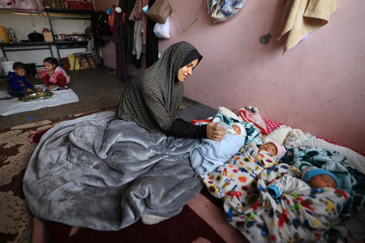 Iman Al Masri, a displaced Palestinian who fled from her home in Beit Hanoun with her family to escape Israeli bombardment, feeds one of her quadruplets — with the fourth still being treated in hospital —as they take shelter at a school in Deir Al Balah in the central Gaza Strip on Wednesday. — AFP