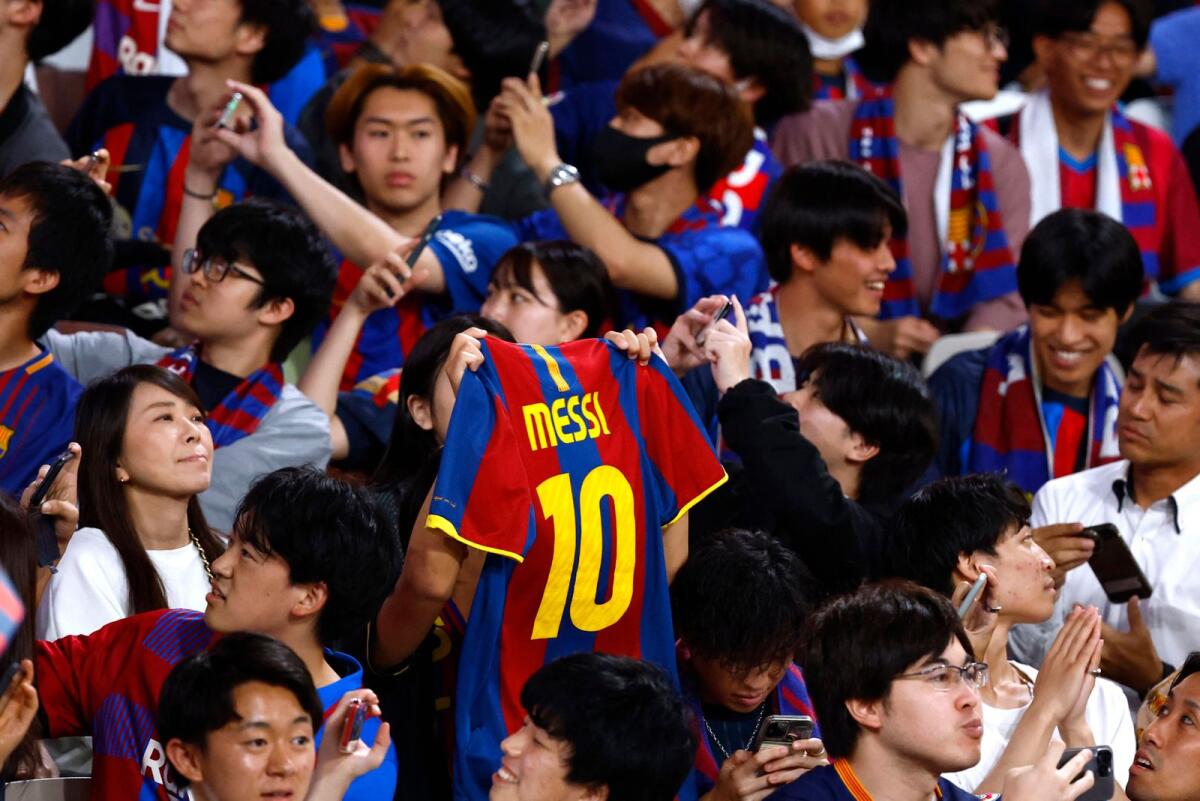 A FC Barcelona fan holds a jersey of Lionel Messi before the friendly between Vissel Kobe and Barcelona in Tokyo on Tuesday. — Reuters