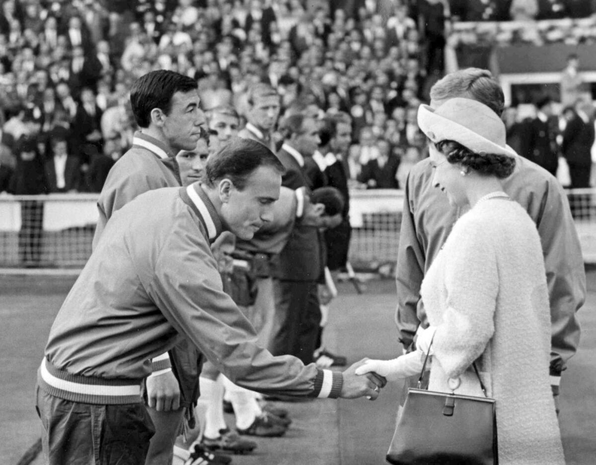 Britain's Queen Elizabeth II shakes hands with England defender George Cohen as she was introduced to the England team before the start of the World Cup match between England and Uruguay on July 11, 1966. (AP file)