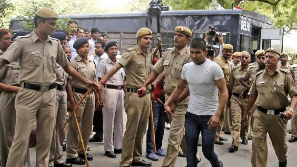 Strict security surrounds Vinay Sharma (wearing white T-shirt), one of the four men sentenced to hang for fatally raping a young woman on a bus as he makes his way to court in Delhi