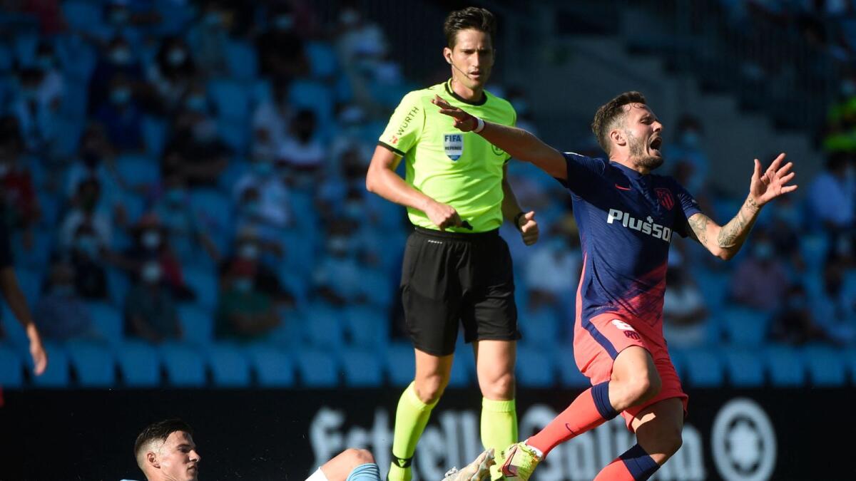 Celta Vigo's Santi Mina (left) tackles Atletico Madrid's Saul Niguez during the Spanish League . — AFP
