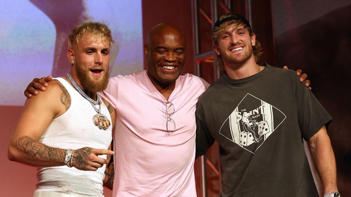Anderson Silva poses for a photo between Jake Paul and brother Logan Paul