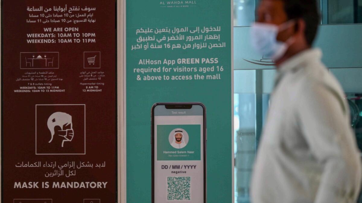 A signboard in front of a mall in Abu Dhabi tells visitors should have a green pass on Al Hosn app to enter the mall. Authorities suspended the rule on Friday until the app is updated. — Photo by Ryan Lim
