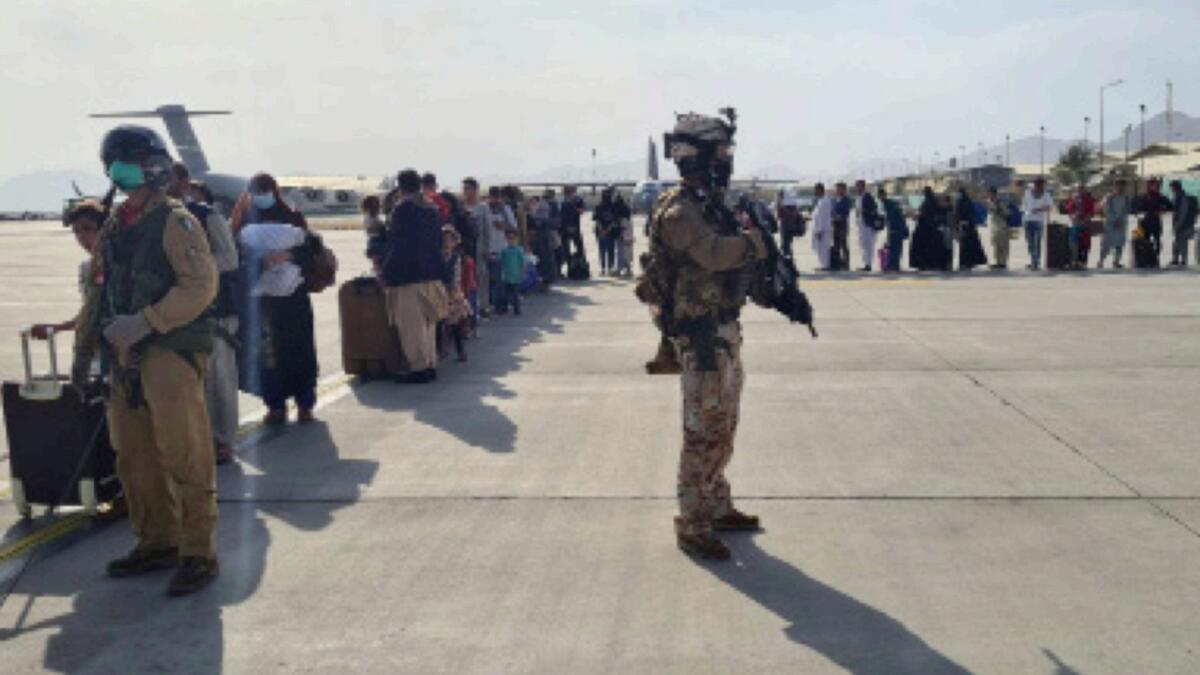 Afghan evacuees queue before boarding Italy's military aircraft during evacuation at Kabul's airport. — Reuters
