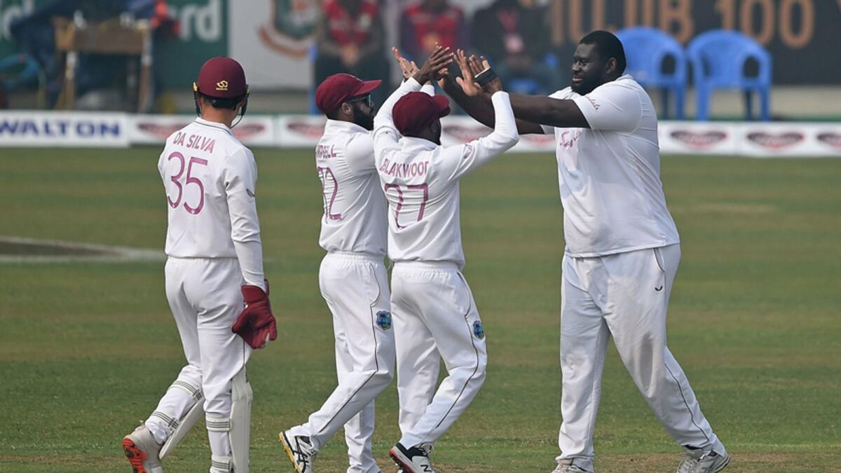 West Indies' Rahkeen Cornwall (right) celebrates with his teammates after the dismissal Bangladesh's Mohammad Mithun (not pictured) during the third day of the second Test match at the Sher-e-Bangla National Cricket Stadium in Dhaka on Saturday. — AFP