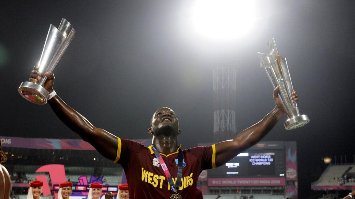 West Indies captain Darren Sammy poses with a pair of trophies as he celebrates after victory in the World T20 cricket tournament final match between England and West Indies at The Eden Gardens Cricket Stadium in Kolkata on April 3, 2016.