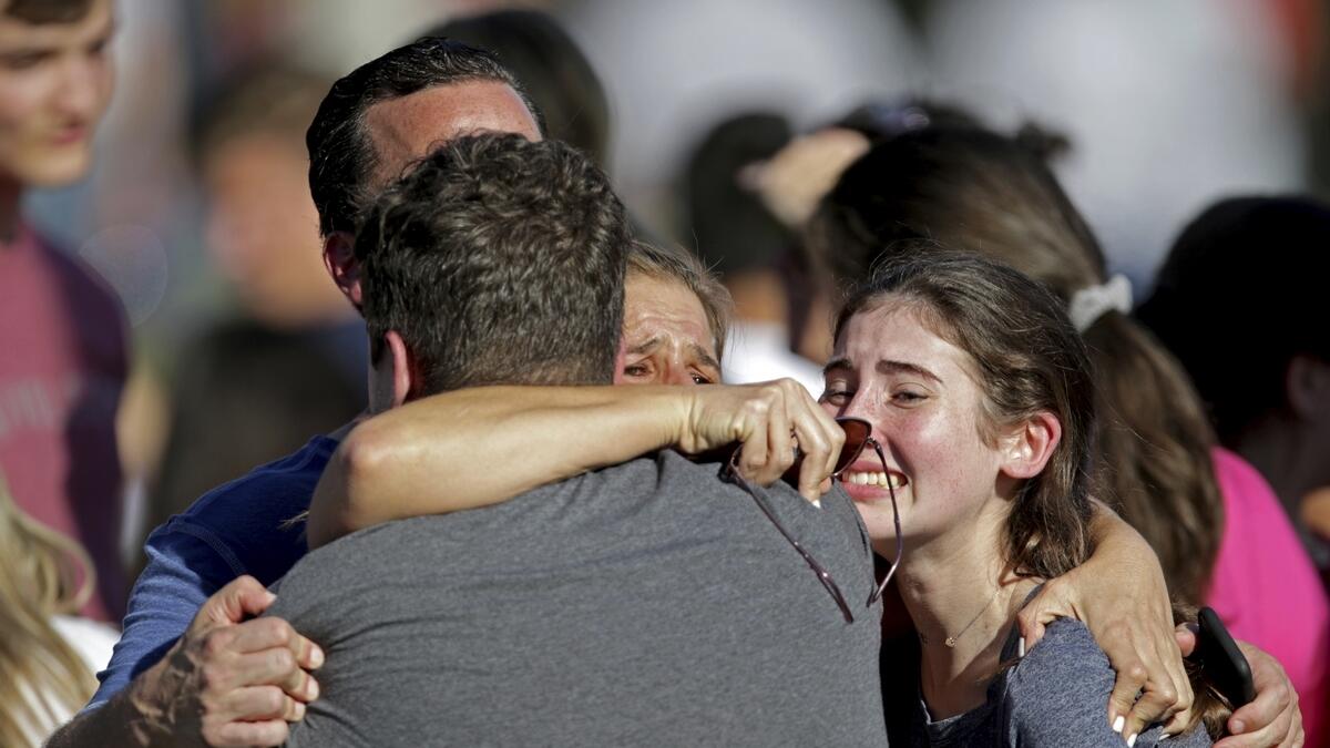 A family reunites following a shooting at Marjory Stoneman Douglas High School in Parkland, Florida.-AP