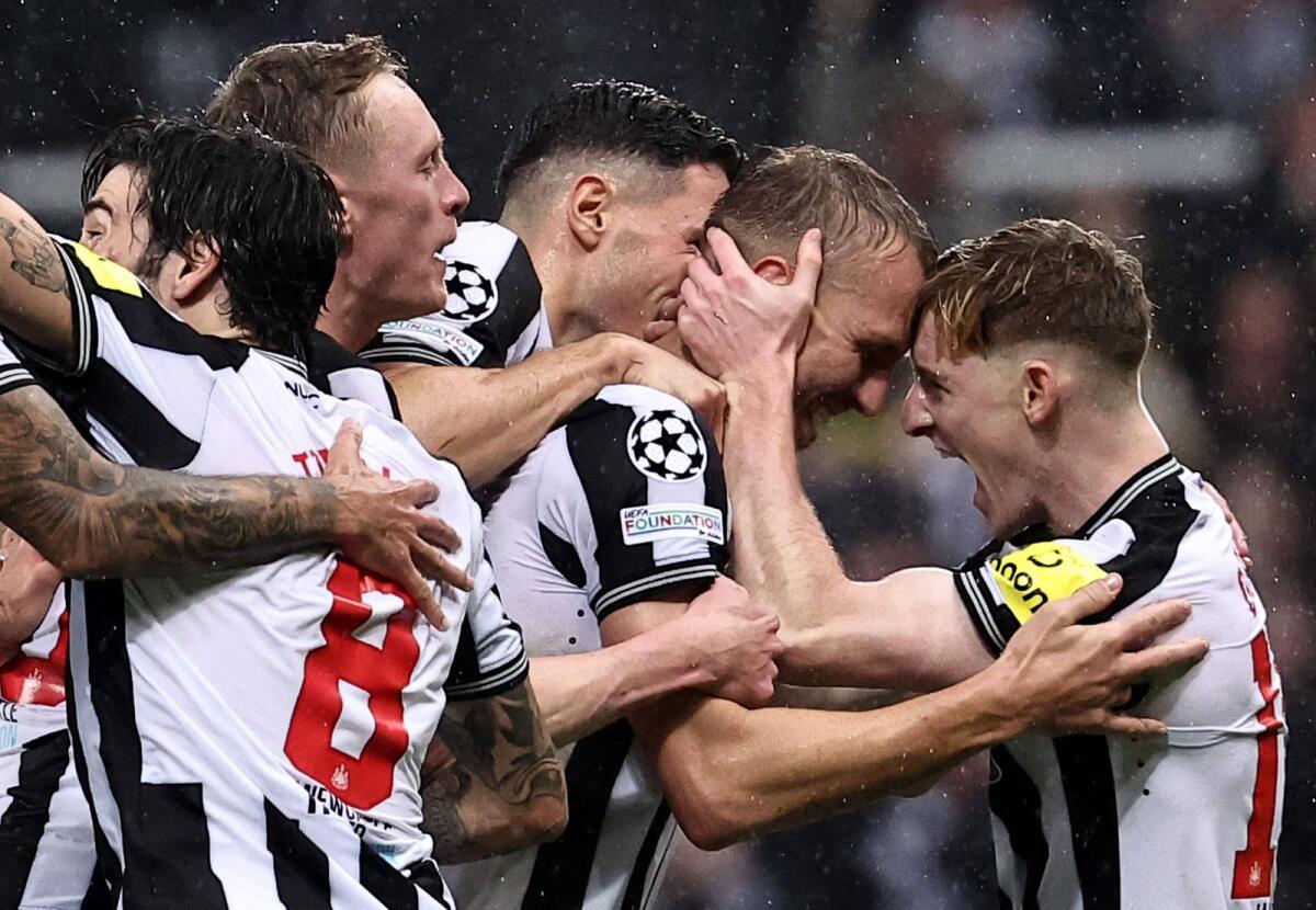 Newcastle United's Dan Burn (2R) is mobbed by teammates after scoring the team's second goal. — AFP