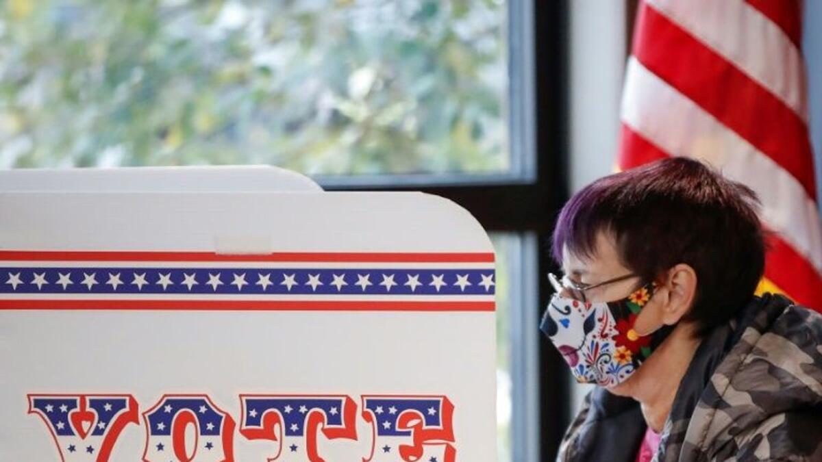 A woman casts her ballot on the first day of in-person early voting for the November 3rd US election in Milwaukee, Wisconsin, on October 20, 2020.