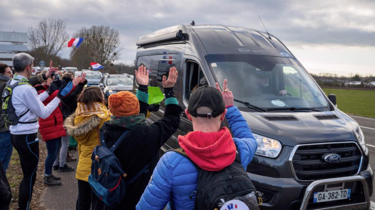 Supporters of the 'Freedom Convoy' (Convoi de la Liberte) cheer participants leaving Strasbourg, northeastern France. — AFP