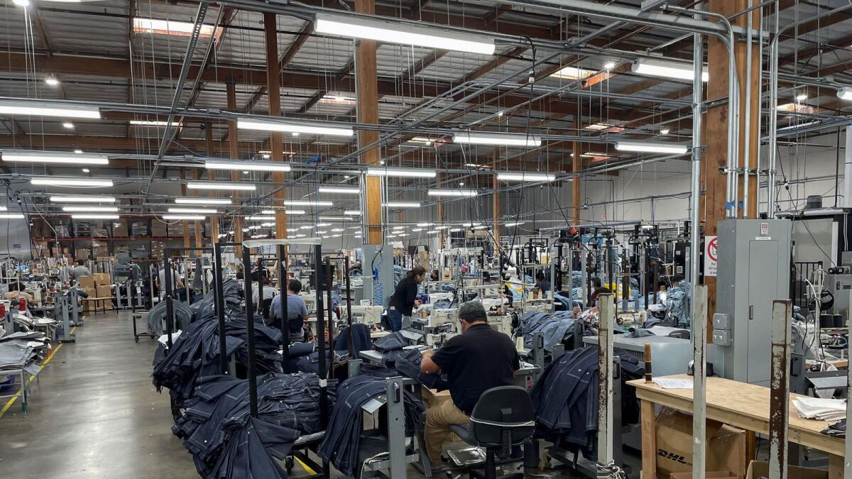People work at Saitex's factory, which experiments with new robots to cut the cost of making blue jeans, in Los Angeles, California. — Reuters