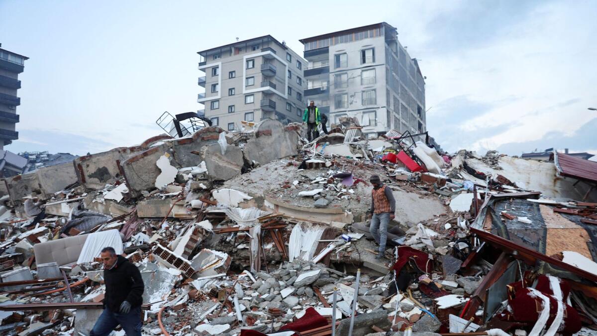 People walk amid rubble following an earthquake in Hatay, Turkey, February 7. The death toll in the devastating earthquake that hit Turkey and Syria has crossed 41,000, according to latest reports. REUTERS