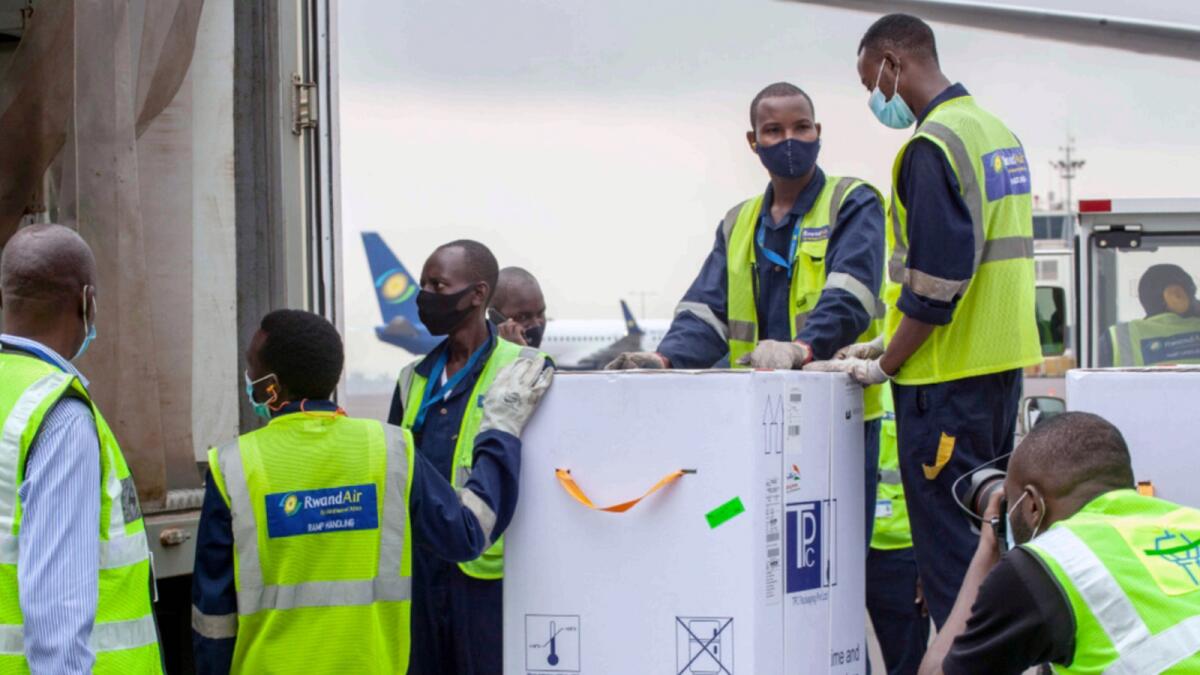 AstraZeneca Covid-19 vaccines are received by airport workers at the airport in Kigali, Rwanda as part of the Covax global initiative. — AP file