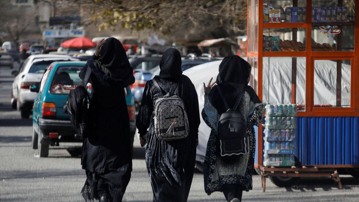 Afghan female students walk near Kabul University last month. — Reuters file