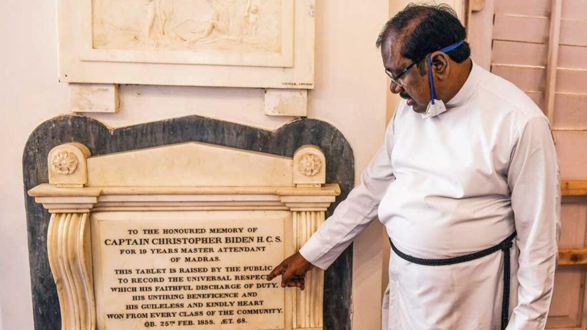 A pastor shows a memorial tablet of Christoper Biden, a potential ancestor of Joe Biden, at St George’s Cathedral in Chennai. — AFP file photo
