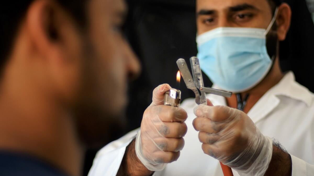 A sterilised razor gets the fire treatment by a hairdresser at a salon in Dubai on Thursday for extra safety. According to guidelines, shaving razors must be stored in sterilisation boxes but some barbers prefer to warm them further before use for greater safety. Photo: Shihab/Khaleej Times