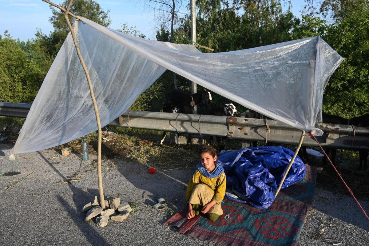 A displaced girl waits for assistance in her tent at a makeshift camp after fleeing from her flood hit home following heavy rains in Charsadda district of Khyber Pakhtunkhwa province on Wednesday. — AFP
