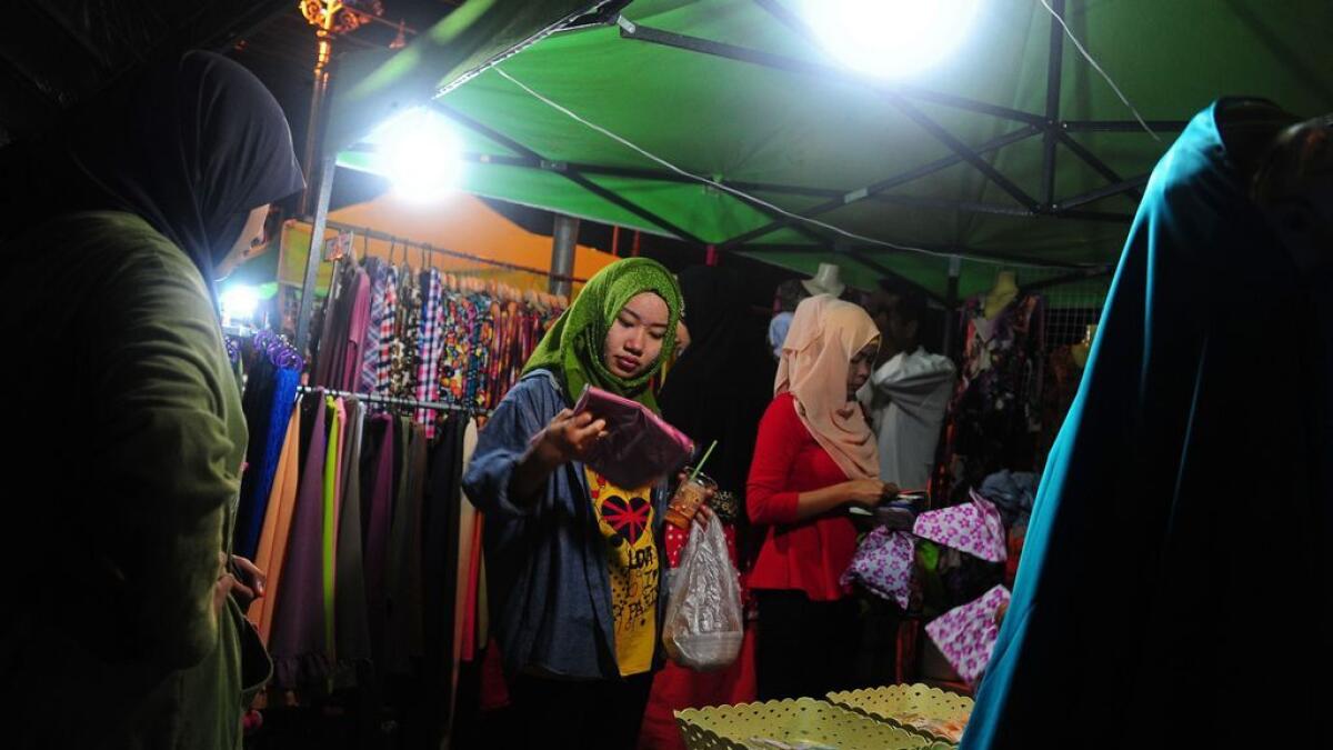 This picture taken on July 3, 2016 shows women shopping for clothing at a market in Thailand's southern province of Narathiwat ahead of the Eid al-Fitr festival.