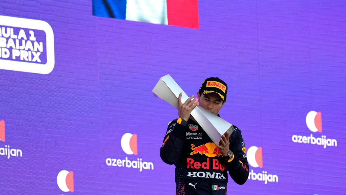Red Bull driver Sergio Perez of Mexico kisses his trophy on the podium after winning the Azerbaijan Grand Prix. — AP