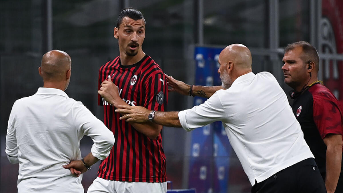 AC Milan's Zlatan Ibrahimovic (second left) argues with his manager Stefano Pioli after he was substituted during a Serie A match against Bologna. - AFP