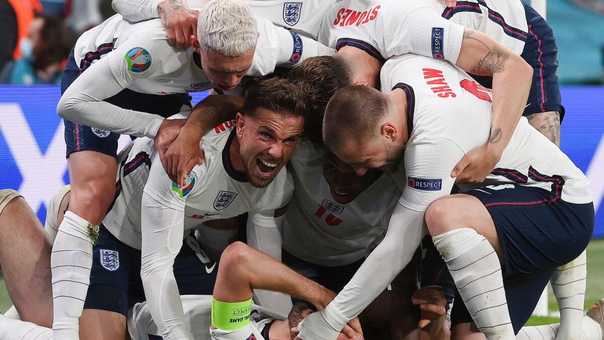 England forward Harry Kane (bottom) celebrates with teammates after scoring against Denmark. (AFP)