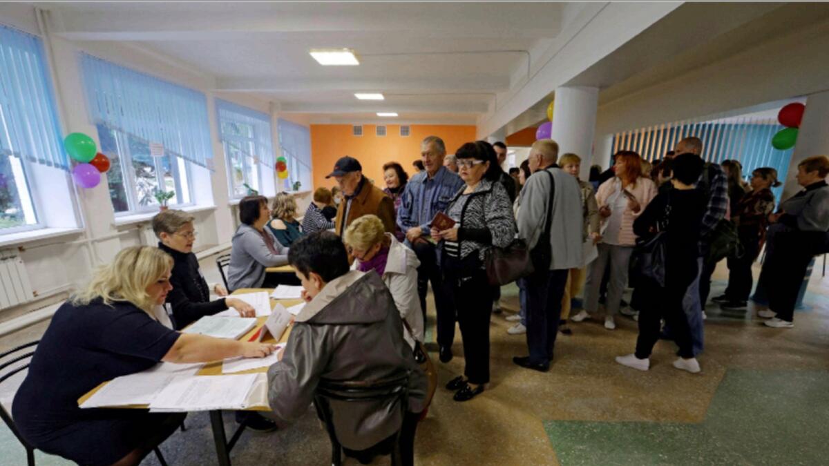 People receive their ballots at a polling station during a referendum on the joining of the self-proclaimed Donetsk People's Republic (DPR) to Russia. — Reuters