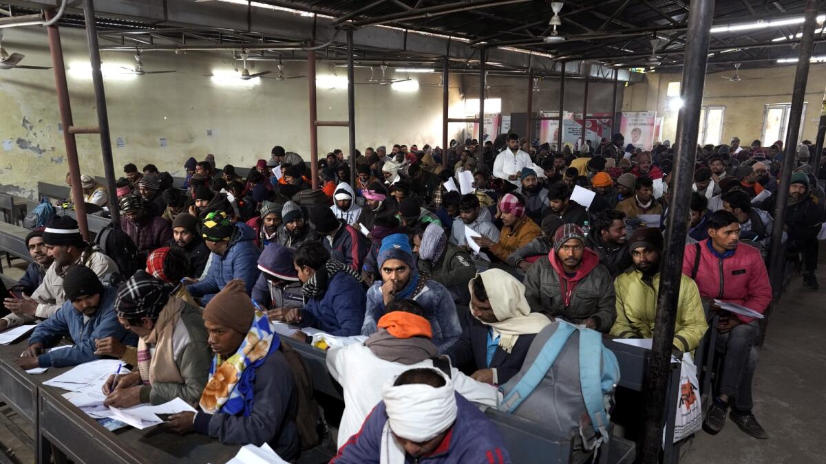 Indian workers aspiring to be hired for jobs in Israel fill their forms during a recruitment drive in Lucknow. — AP